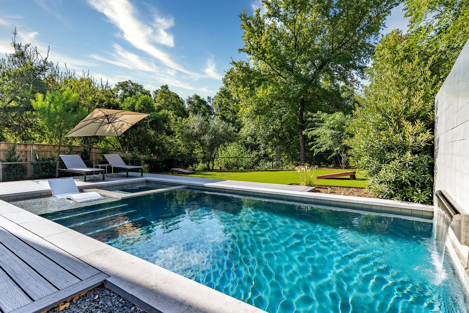 Finished pool and lounge area with lawn in distance