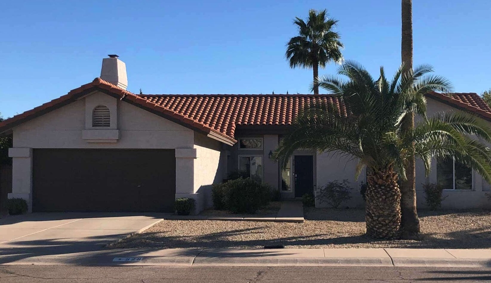 Before photo of front yard with bare landscaping and no patio