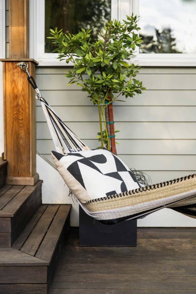 Close up of new hammock on their back deck with modern black and white pillow.