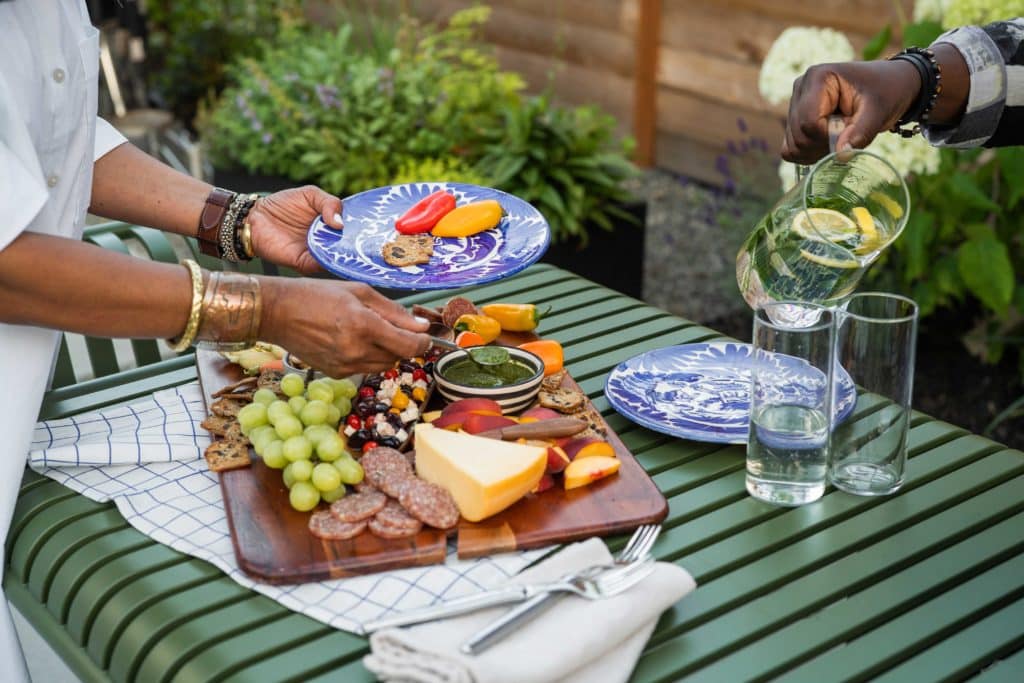 Close up of Edith and Bobby enjoying charcuterie board and lemon water on their new outdoor dining table.