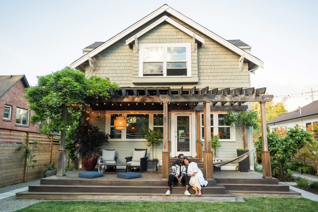 Homeowners Bobby and Edith sitting on the steps of their new pergola-covered deck.