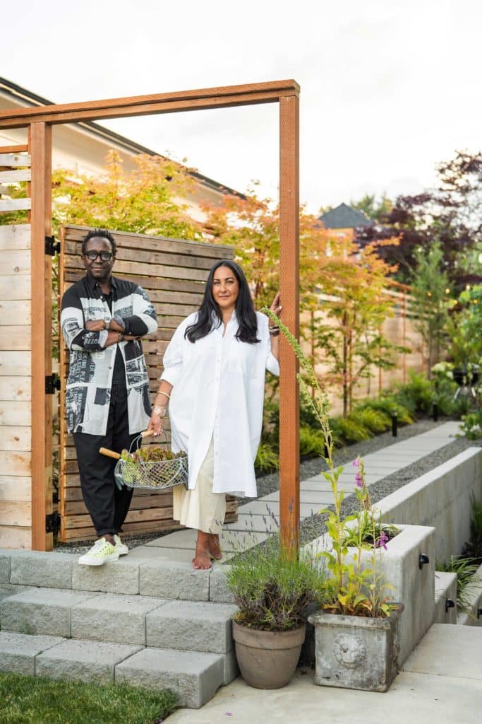 Bobby and Edith standing at the end of the concrete paver walkway elevated above the yard on the retaining wall.