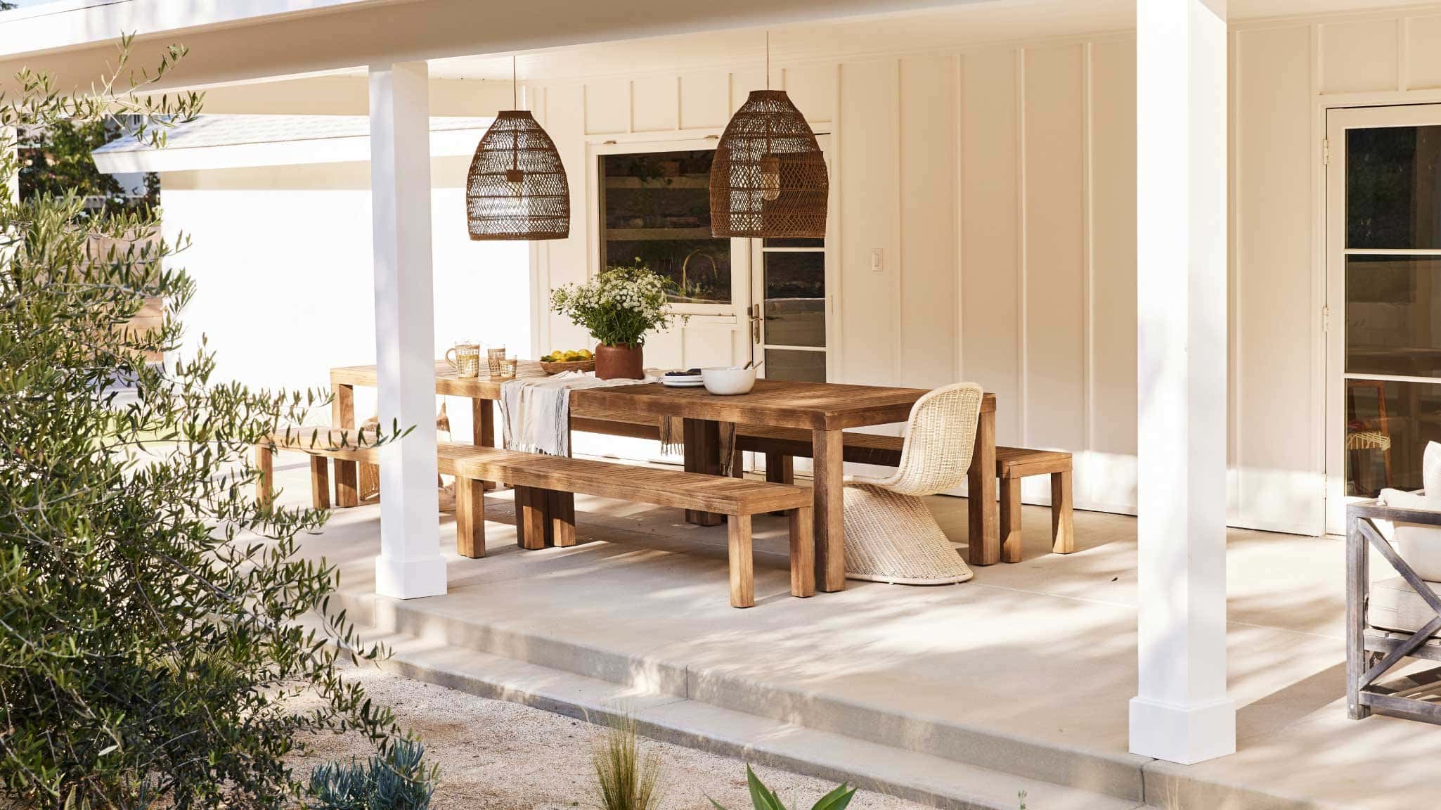 View of back deck from yard with stylish furniture and hanging lights