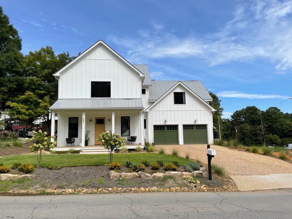 View of the modern farmhouse front yard, pea gravel driveway, and front porch. 